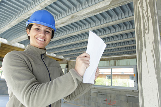 Female construction worker in blue hard hat, smiling