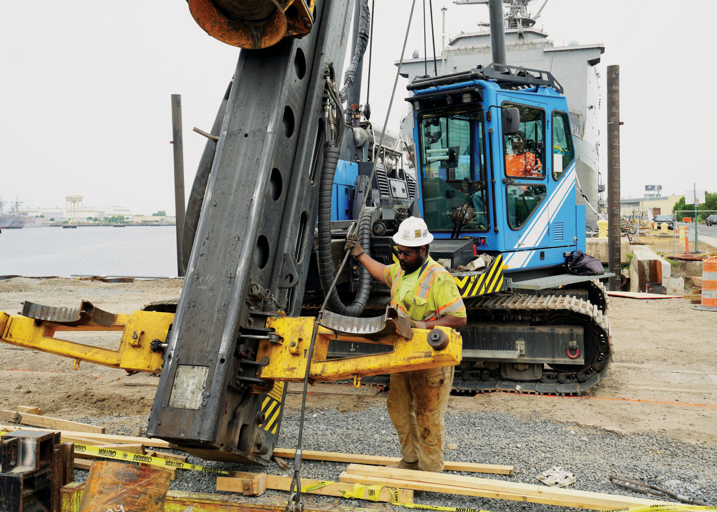 Worker inspecting sheet pile installation