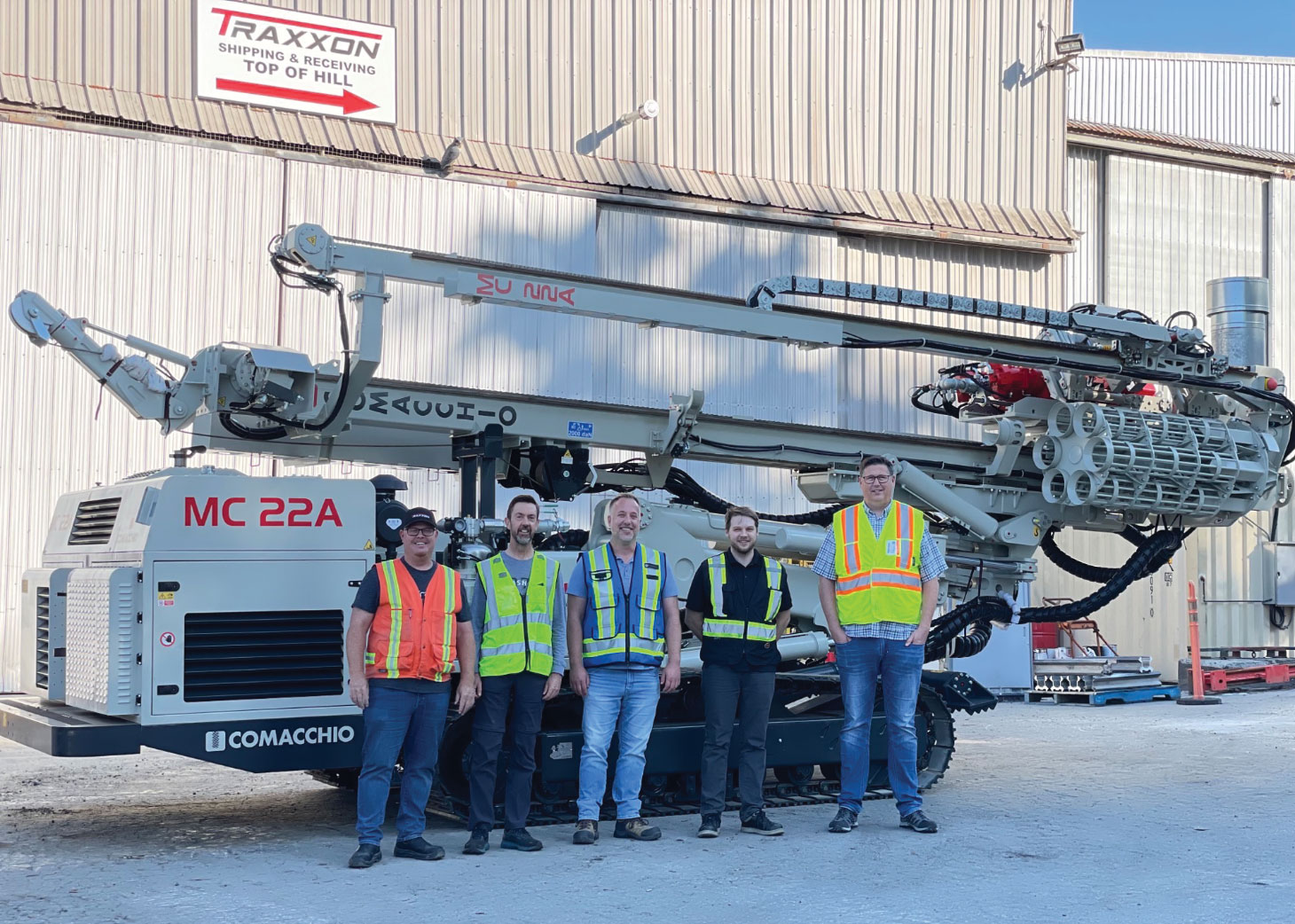 Traxxon team members posing in front of Comacchio vehicle