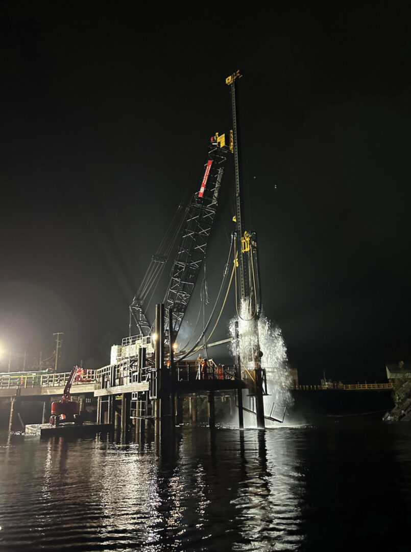 Nighttime shot of heavy equipment driving piles at Nairn Falls generating system