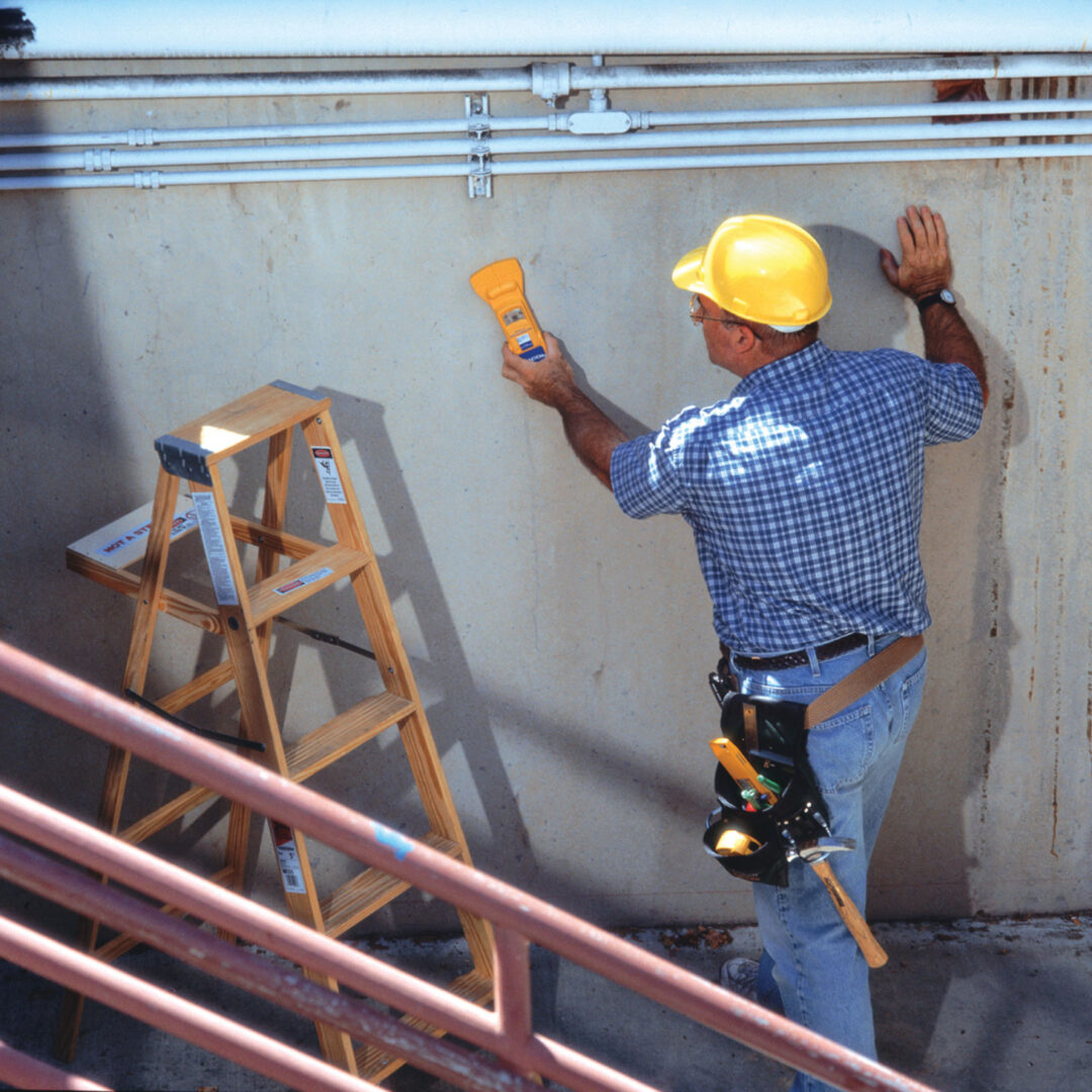 Worker scanning concrete wall