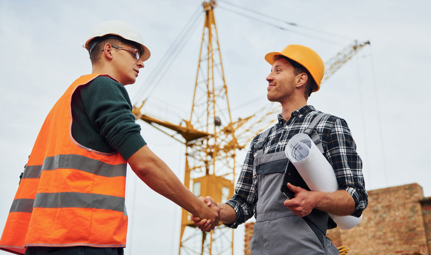 Two construction workers shaking hands on the job site