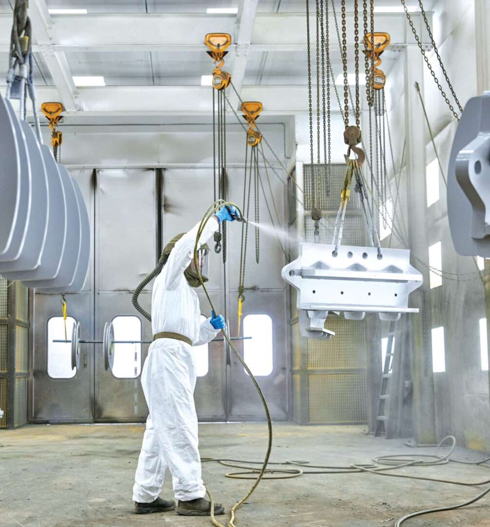 Employee in PPE equipment spraying part