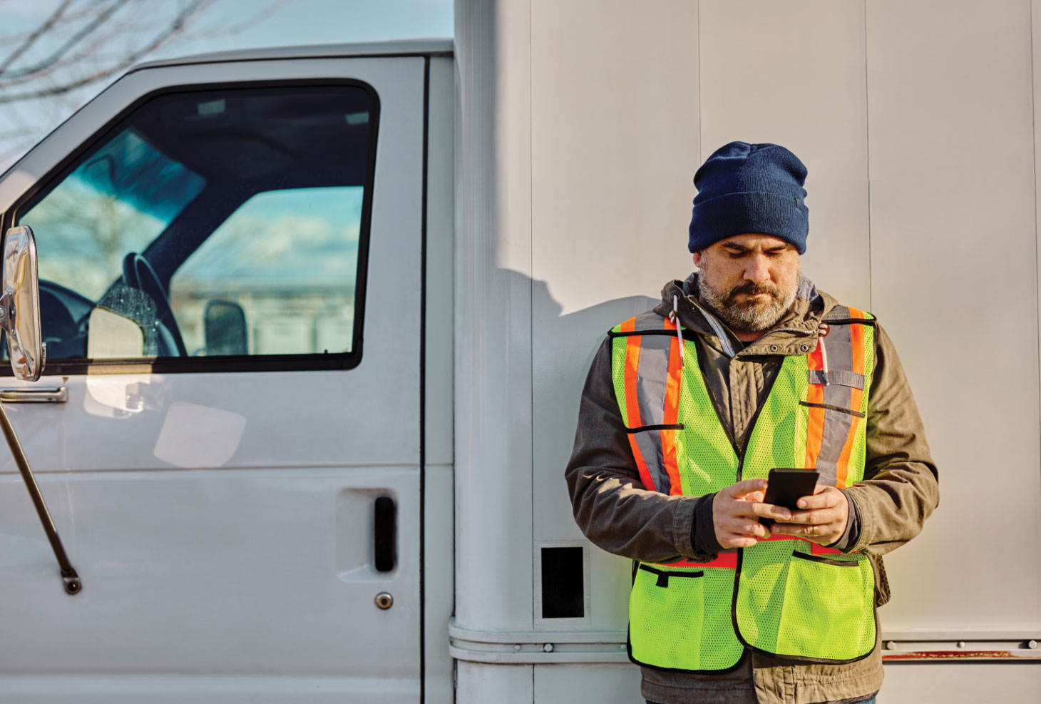 Man in highvis vest checking phone