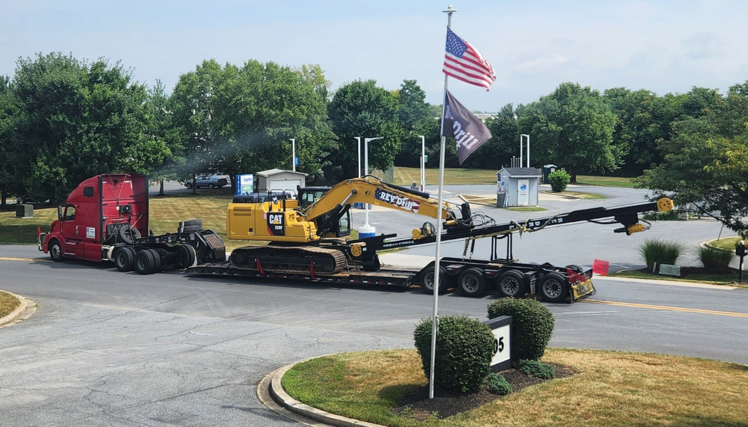 REV Drill being transported on truck bed with American flag flying in foreground